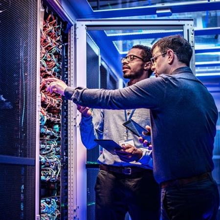 Men inspecting servers in data center